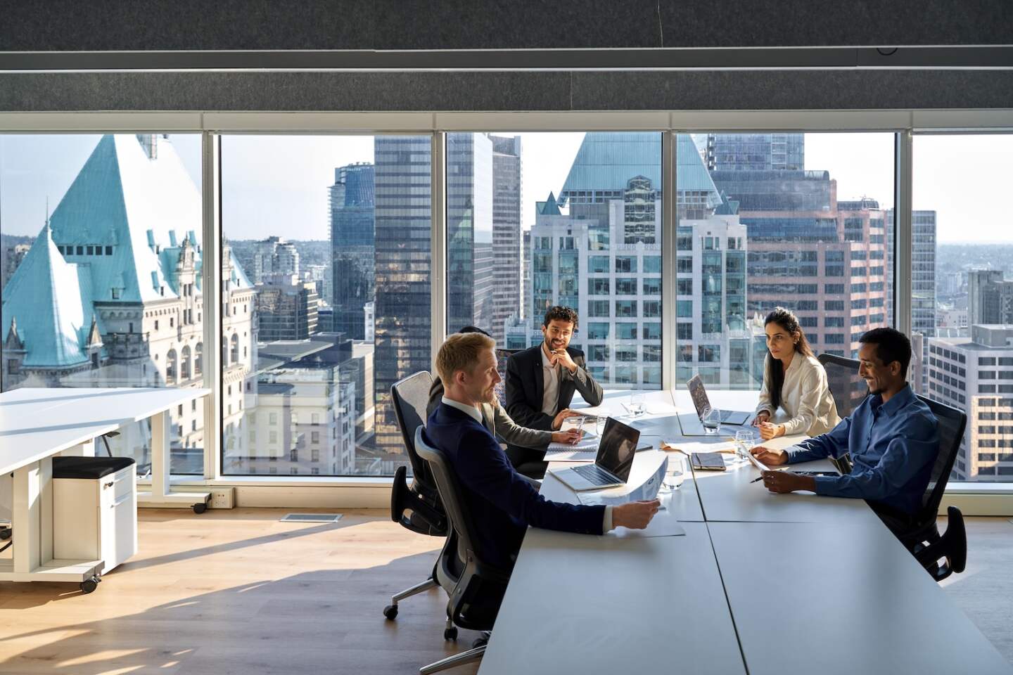 Busy young professional international board executives, diverse team people group discussing financial results managing company project working together in modern meeting room.