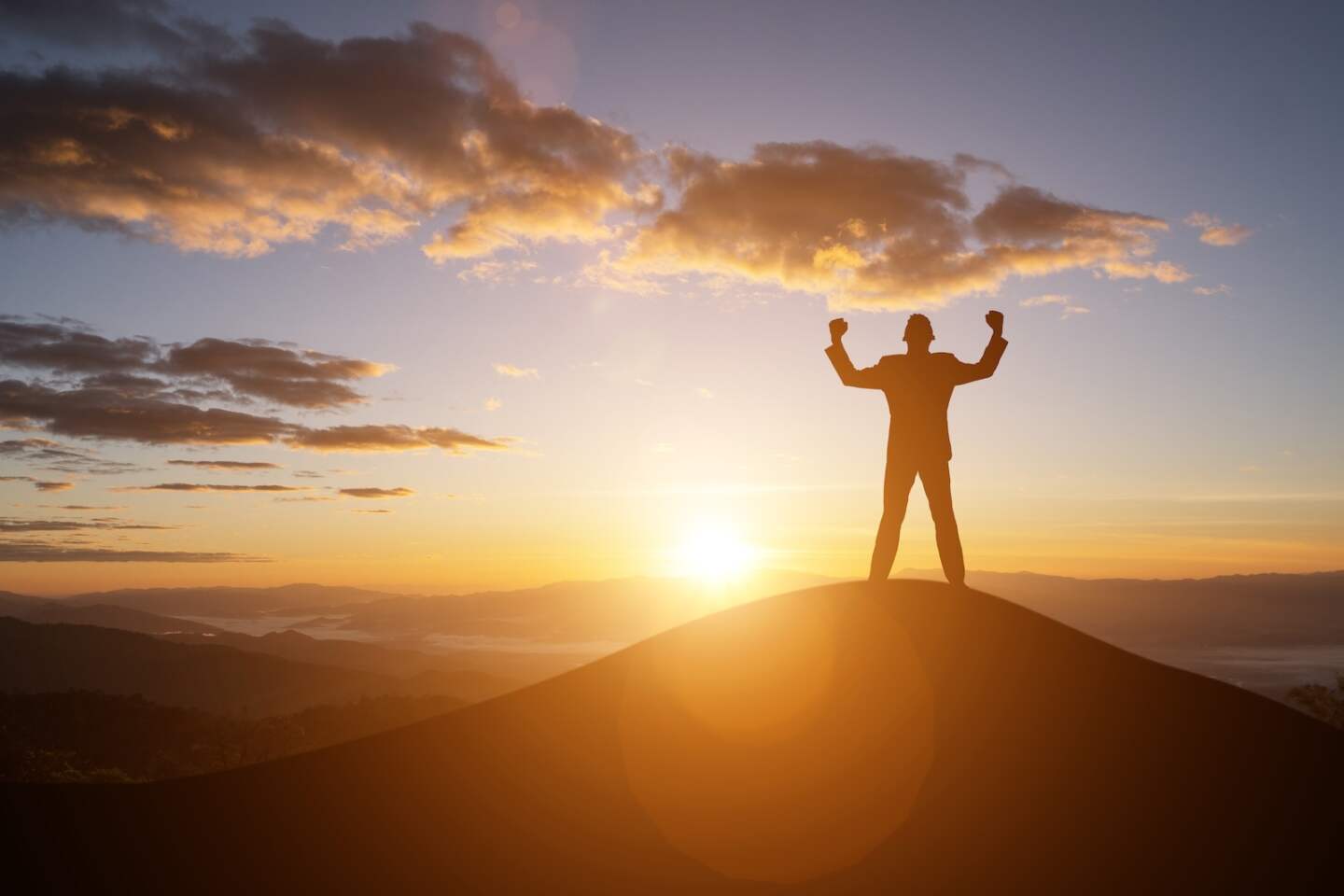 silhouette successful man on the top of the hill and the sunset