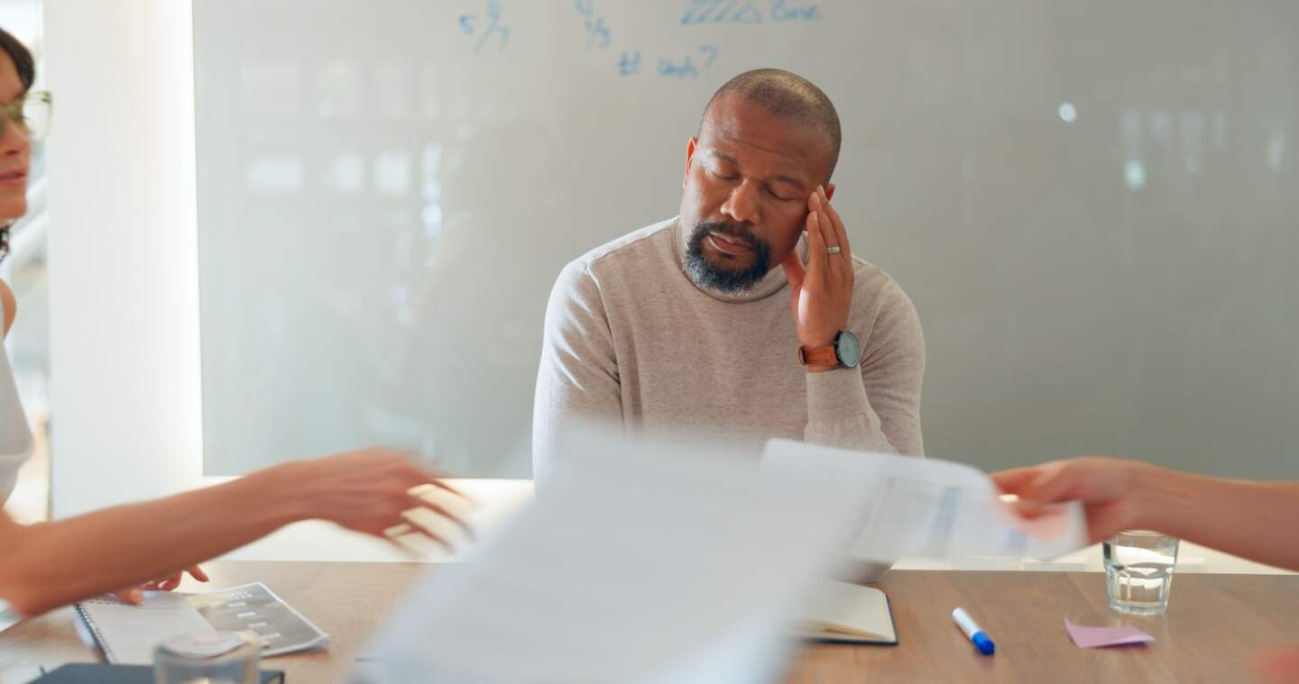 Black man, headache and burnout, stress and frustrated in meeting, paperwork and mental health with.
