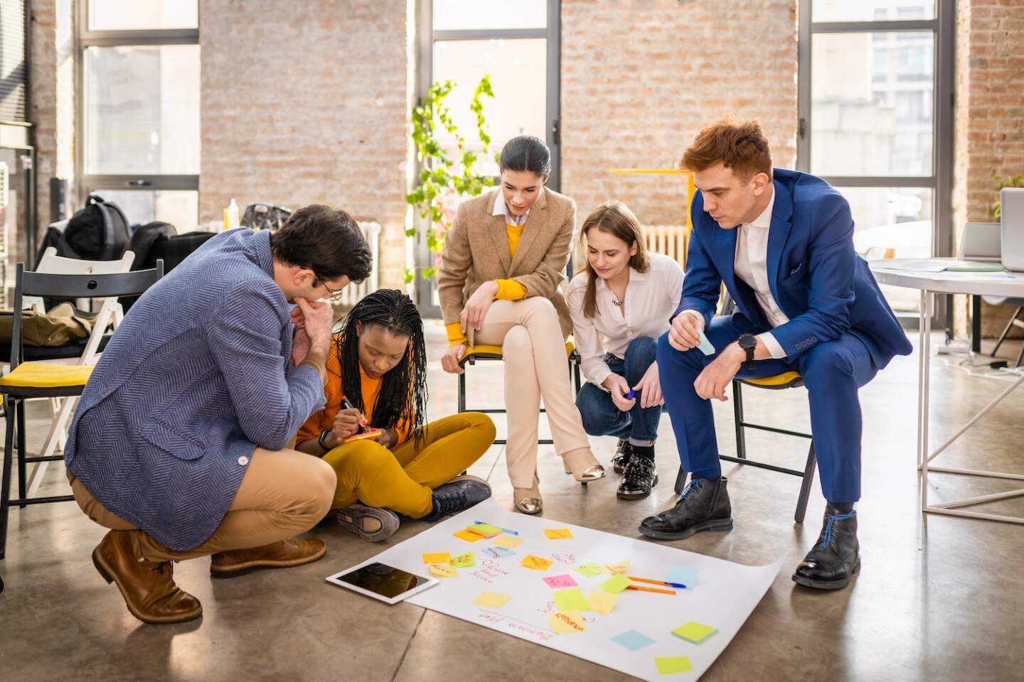 Project managers and employees brainstorming on ideas - Multi-ethnic group of workers having business meeting in a start-up office