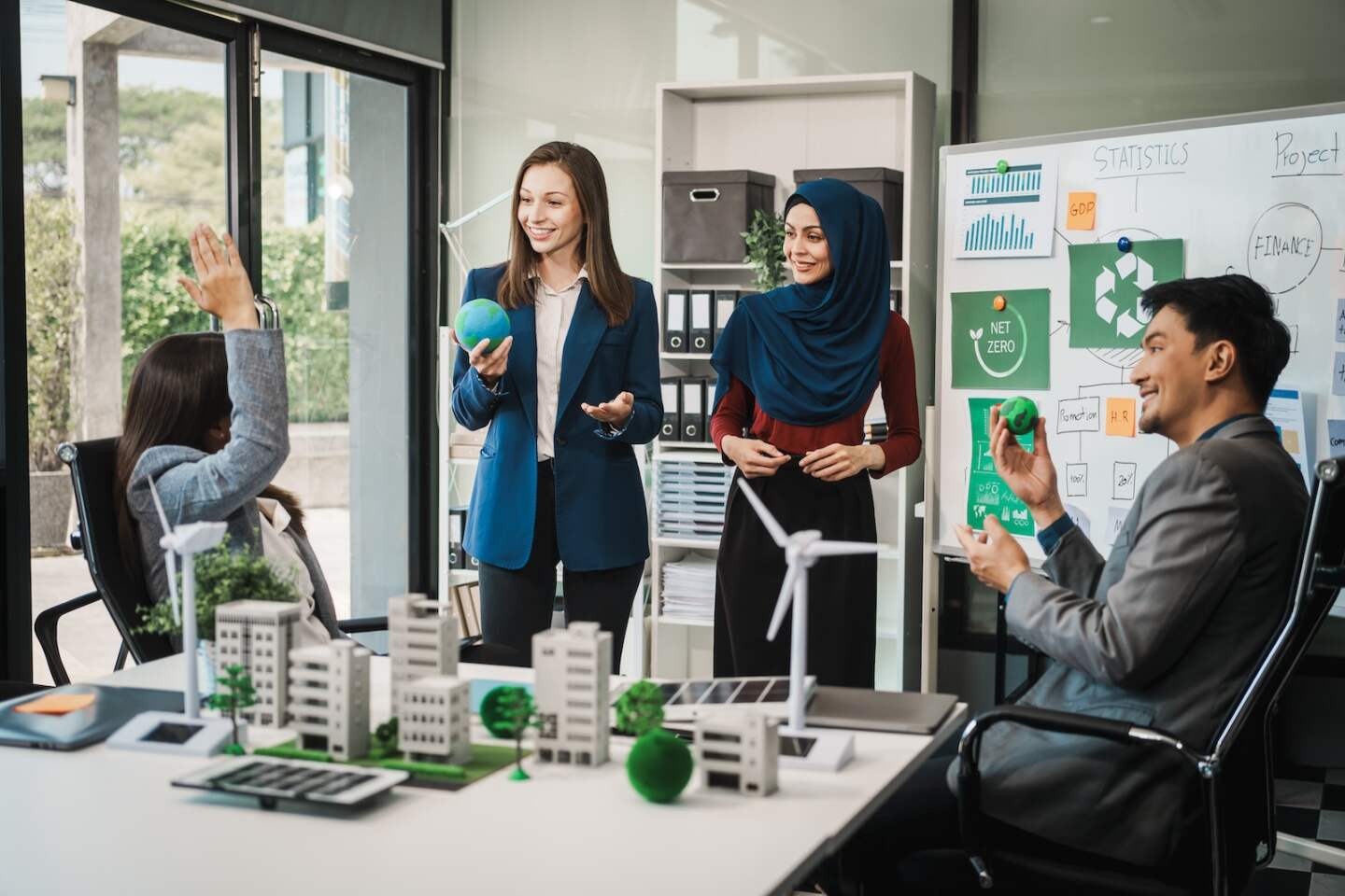 Diverse team, middle-aged Asian businessman, Caucasian young businesswoman, Muslim hijab-wearing