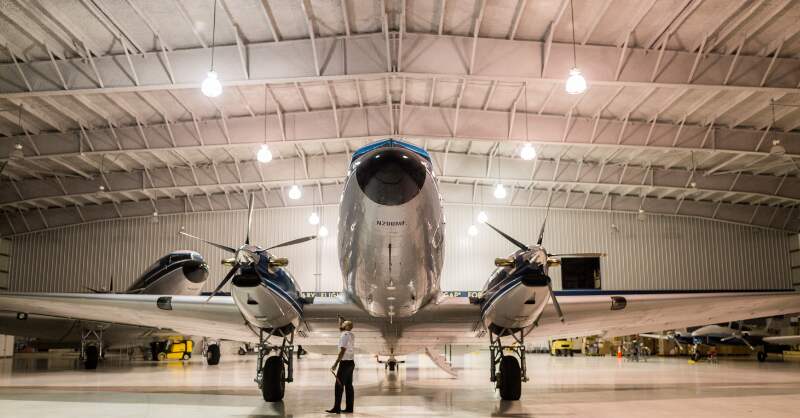 man inspecting a plane inside a hangar