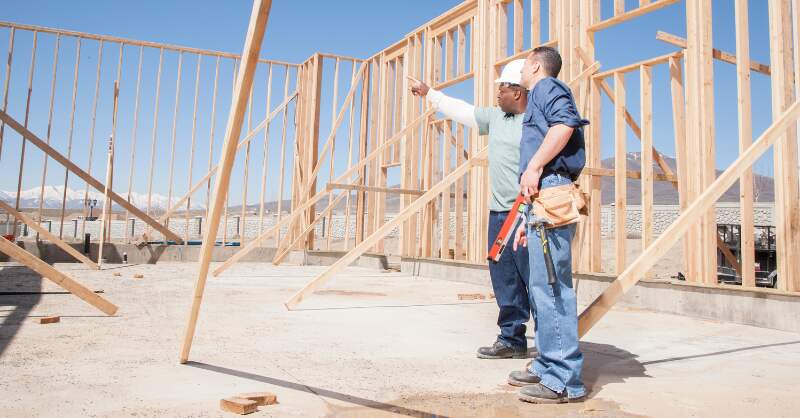 two men at a construction site for a house