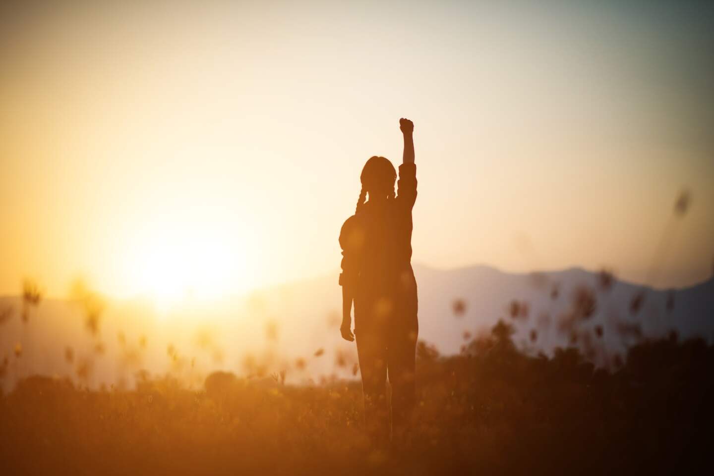Silhouette of woman praying over beautiful sky background