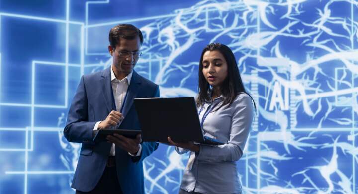 AI researcher and colleague working with artificial intelligence neural networks modern lab. Computer scientists collaborating on developing AI system in high tech workplace